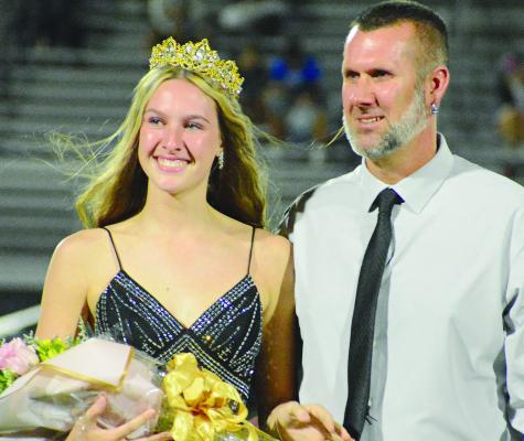 SENIOR KARLEIGH HAHN (left) beams alongside her father, Kevin, after being crowned Homecoming Queen during halftime ceremonies at the Excelsior Springs vs. St. Joseph Central football game. SHAWN RONEY | Staff