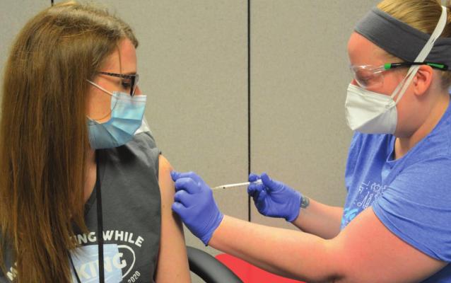 VACCINE goes into Clay County Health Center Program Manager Corrie Courtney’s arm.