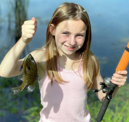 RYLEE PENSICK, 8, shows off her prized bluegill, caught June 11 in Powell Lake. “He sure puts the blue in bluegill,” says Rylee’s brother, Junior Pensick. BRIAN RICE | Staff