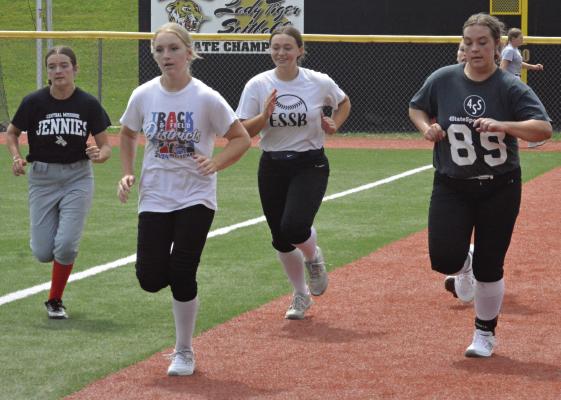 MEMBERS OF the Excelsior Springs prep softball program sprint along the warning track at Miracle Field on the first day of fall sports practices. The girls are slated to open the regular season Aug. 30 with three round robin tournament games at Lathrop. SHAWN RONEY | Staff