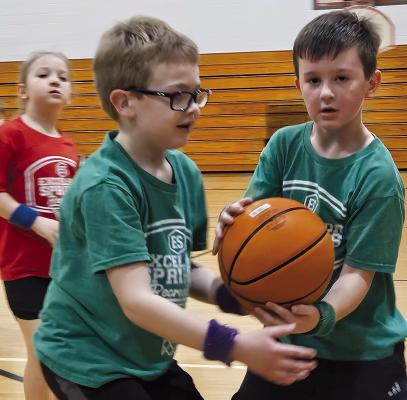 EASTON HIMBURY (left) and Kelce Stonum secure the ball during an Excelsior Springs eight-and-under youth basketball game at the middle school. MIRANDA JAMISON | Staff