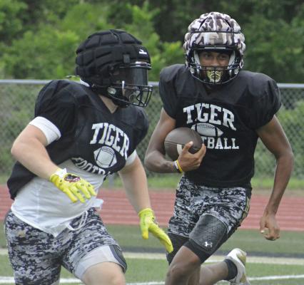 TAKING SOME reps at wide receiver, Excelsior Springs upperclassman Marquez McCant (right) looks for running room on a sweep during an offseason scrimmage session. SHAWN RONEY | Staff