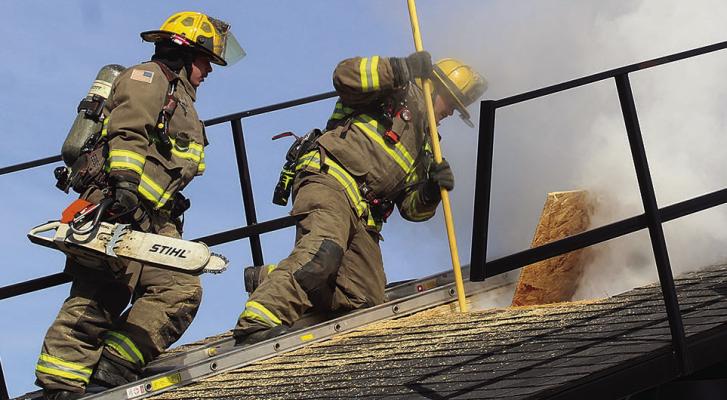 EXCELSIOR SPRINGS FIREFIGHTERS Camden Dickey (left) and Jonah McKennon cut through a roof prop as part of a vertical ventilation demonstration. MIRANDA JAMISON | Staff