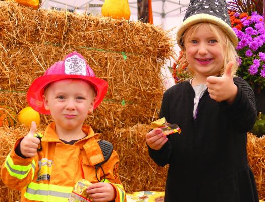 BUBBA (LEFT) AND Evelyn Harrell give a thumbs up in approval of the fall festival farmers market event as they munch on gummy bears. ELIZABETH BARNT | Staff