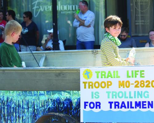 TRAIL LIFE TROOP MO-2820 members take part in the parade via a boat, complete with fishing poles in hand.