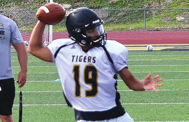 JUNIOR QUARTERBACK hopeful Dacey Hall draws back to throw while under coach Mark Faubuion’s watchful eye. DUSTIN DANNER | Staff