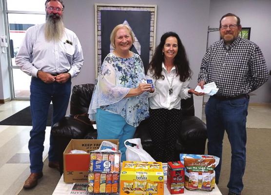 AT THE EXCHANGE of donation items and cash are, from left, Pastor Art Endsley, Barbara Britt, Michele Orpin of the Veterans Community Project and Tim O’Dell.