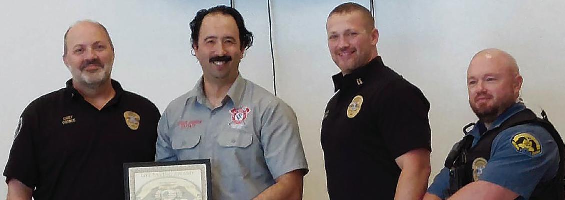 CLAYCOMO POLICE CHIEF Matt Coonce (from left) presents Claycomo Fire Captain Apurou Johnson with the Lifesaving Award, joined by Police Captain Andy Lorenson and Lieutenant Jeff Kirk. Submitted