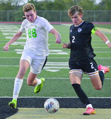 BRADY SCHOONOVER (right) attempts a crossing pass for Excelsior Springs while being challenged by Smithville senior Aiden Verhulst. SHAWN RONEY | Staff