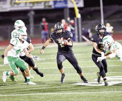 ON A night when yards prove difficult to come by, Excelsior Springs senior quarterback Chance Moreland finds a hole in the line and seeks more running room during the Tigers’ 42-8 Sept. 23 home loss to Smithville. DUSTIN DANNER | Staff