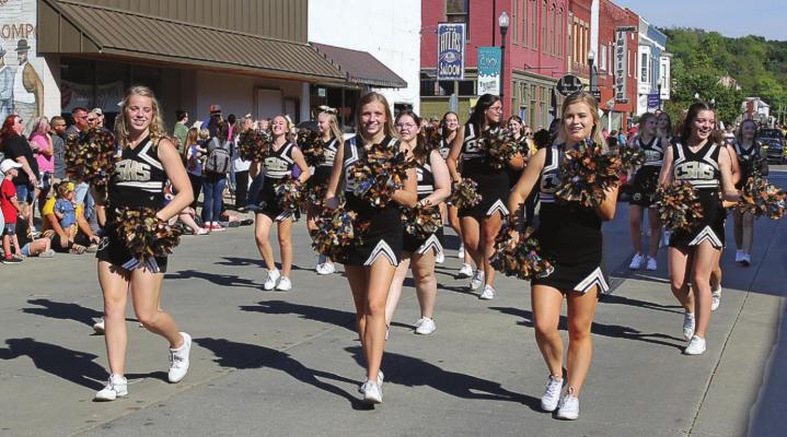 AWNINGS and signs help brighten downtown streets, as seen during the Oct. 8 Excelsior Springs High School Homecoming Parade while cheerleaders march along Broadway Avenue. Downtown Excelsior Springs Partnership grants are available to help add, replace or improve awnings and signs downtown. J.C. VENTIMIGLIA | Staff