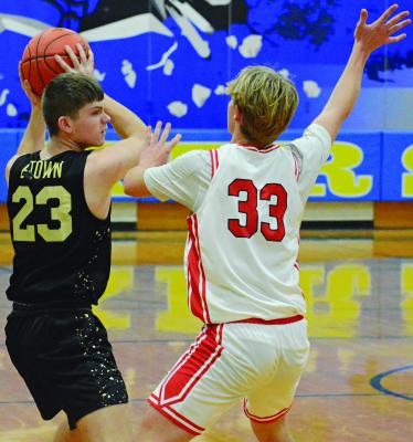SOPHOMORE SPENCE GIBBS (left) shields the ball while guarded by Richmond’s Jack Minton during Husker Classic action. Gibbs and his Excelsior Springs varsity boys teammates trailed the Spartans 33-31 after three quarters and fought to keep it close the final quarter before falling 61-52 Monday at Higginsville. The Tigers were slated to continue Husker Classic play against Odessa. SHAWN RONEY | Staff