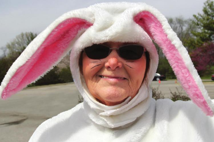 IN THE ROLE of the Easter Bunny, rehab employee Robyn Kinney grins for an appreciative audience of community children.