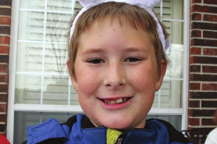 HAPPY IN HOPPY bunny ears for the hunt, Isaac Hutfles, 8, shows off his take. Some eggs are redeemable for prizes. J.C. VENTIMIGLIA | Staff