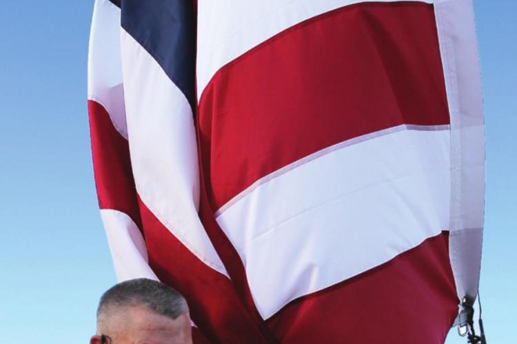 ARMY Sgt. Bill Gaines helps to raise the flag. J.C. VENTIMIGLIA | Staff