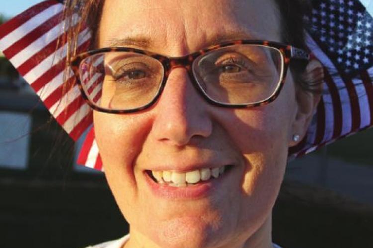 STUDENTS decorate teacher Julee Slater with U.S. flags.