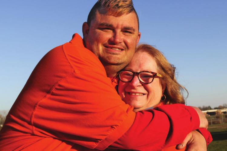 AMONG THOSE who benefit from Special Needs Services activities, James Eubanks hugs Ray County Special Needs Services Director Suzan Breen.