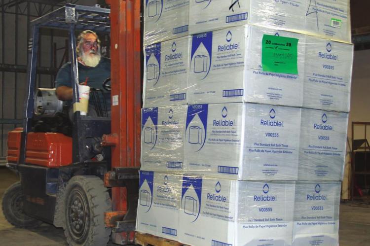 CHURCH OF LIBERTY Pastor Doug Perry drives a forklift while moving a few of the thousands of boxes of paper products into position in the church warehouse in Excelsior Springs. J.C. VENTIMIGLIA | Staff