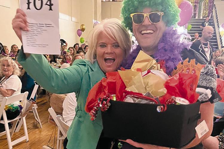 JAKE SIMMONS (RIGHT) PRESENTS the basket of goodies to winning bidder Monica Shane. MONICA SHANE | Submitted