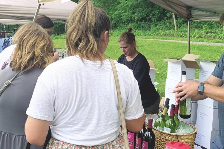 CLETIS AND AMY WEBB serve wine from Giggling Grapes Winery. They are among 20 Missouri wineries attending.