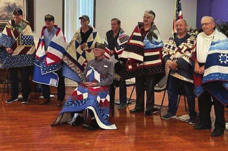 RECEIVING Quilts of Valor are Ronnie Lowery Jr., seated in front, and from left, Timothy Parks, David Bruce Roberts, Barney McCoy, Roy Cheek, Drew Newman, John Elliott and Bernell Raye.