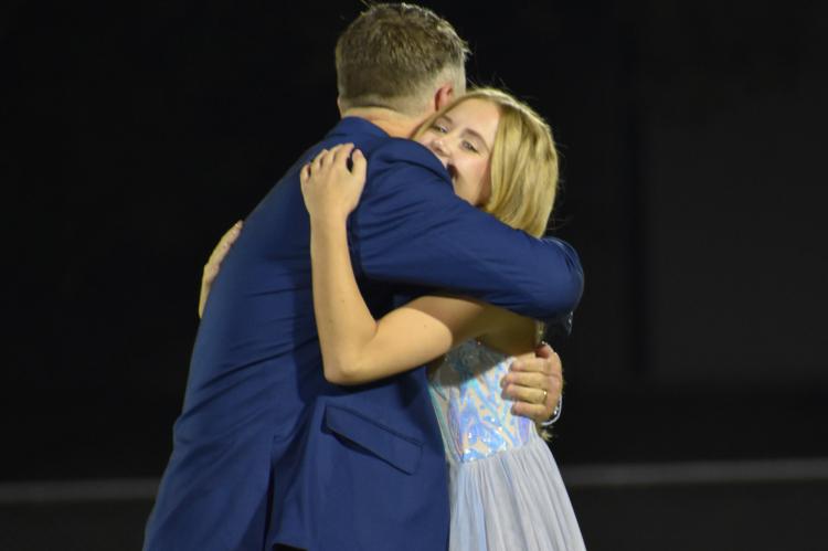 Emily Milledge shares a hug with her father after being announced queen. (Photo by Christi Rice)