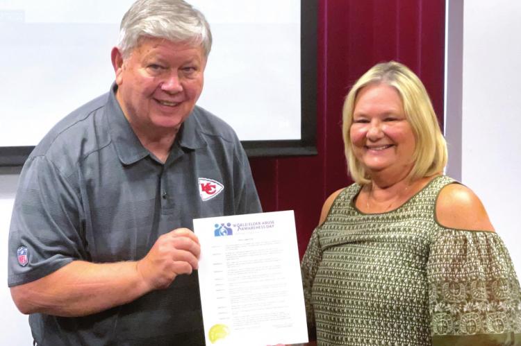 CLAY COUNTY Senior Services Board Member John McGovern receives the World Elder Abuse Awareness Day proclamation from Excelsior Springs Mayor Sharon Powell. BRIAN RICE | Staff photo