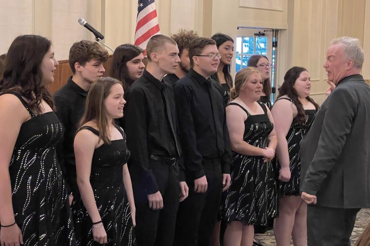 LED BY TIM HARLAND, the Spring Singers sing “The National Anthem.”