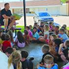 DR. NELSON KANNING of Kanning Dental reads a children’s book about good dental hygiene to youth participants during a program at Lawson City Park. After the story, kids colored dentalthemed activity pages. MIRANDA JAMISON | Staff