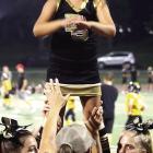 SOPHIA WALSTON reaches the top of a stunt as fellow cheerleaders support her from below.