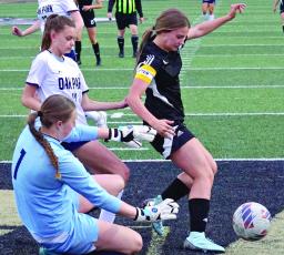 ABBY RASH (right) tries to get around Oak Park’s defense April 10 in the Excelsior Springs Tournament title game. The Excelsior Springs girls place second, winning their first two games and losing 3-0 to Oak Park. DUSTIN DANNER | Staff