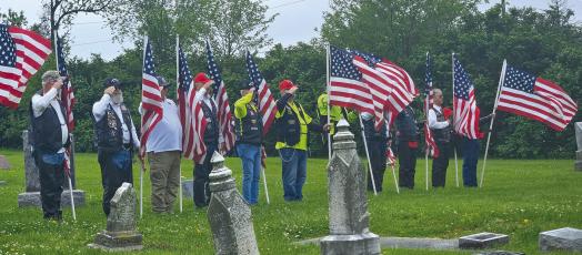MILITARY VETERANS hold American Flags and salute in honor of their fellow soldier Cpl. Charles Ryan Patten, who died in the Korean War. MIRANDA JAMISON | Staff