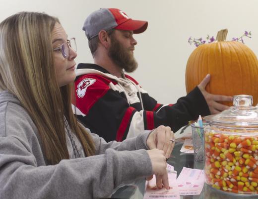 LAUREN (LEFT) and Michael Reavis guess the weight of a pumpkin and how many candy corns were in a jar, while celebrating the businesses one year anniversary. MIRANDA JAMISON | Staff