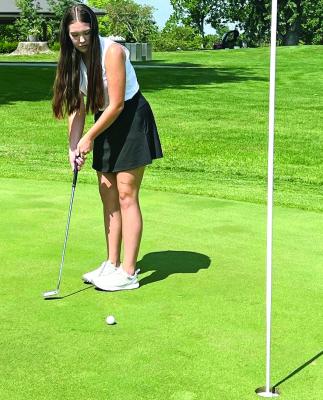 SENIOR KYLEE BALDRIDGE, one of two girls vying to be Excelsior Springs’ No. 1 golfer, drops a putt into the cup during a recent practice at the Excelsior Springs Golf Course. DUSTIN DANNER | Staff
