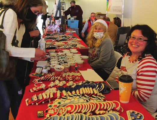 BROWSERS at the Mistletoe Market include Danielle Hague, left, who visits the K3Krafts table, where Carol DuVall and Kara Klein offer hundreds of tiny Christmas ornaments that work individually or as attachments to larger ornaments.