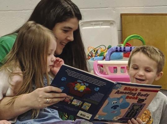 KATHY EMERY (center) reads a story to Vernabelle Souders (left) and Elijah Frost during a Parents as Teachers get together. KATIE FROST | Submitted