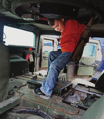 INSIDE the Ray County Sheriff’s Office military surplus MRAP vehicle, Joseph Kinnison, 6, sits in the cloth seat under the turret. SHARON DONAT | Staff affiliate