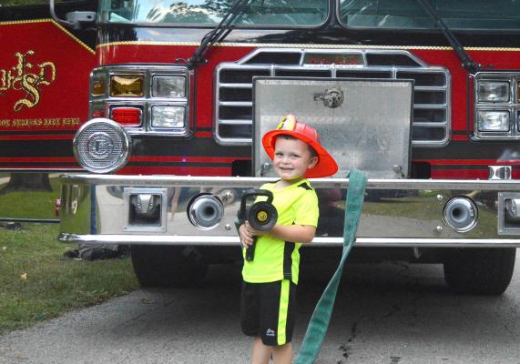 FUTURE FIREFIGHTER Jake Clevenger is ready to put out fires all over Excelsior Springs, as he holds the hose to Pumper No. 1 at the National Night Out for the Excelsior Springs Community Outreach Program on Sept. 16. TARA ALTIS | Staff