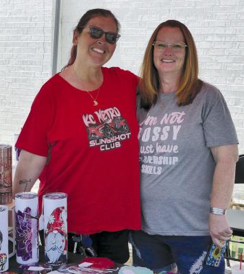 designed travel cups in their booth. MISSY LENTZ (left) and Patty Rector offer custom-