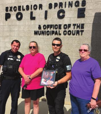 SISTERS Gail Vassmer and Julane Hicks show appreciation for the Excelsior Springs Police Department. From left are Officer Robert Warner, Vassmer, Officer Kenneth Stieh and Hicks. The sisters present Stieh with their thanks and a framed photo of Stieh and their mother, Madolyn Eberts, taken during one of Stieh’s visits with Eberts in the hospital.