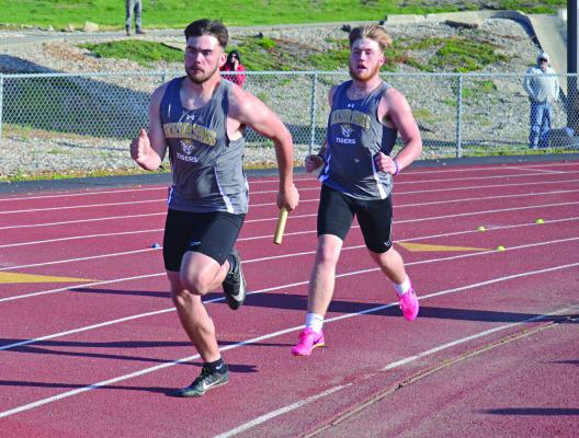 EXCELSIOR SPRINGS sophomore Carson Jackson watches senior Chance Moreland take off after the baton exchange during the boys 400-meter relay April 21 at the Mineral Water Classic at Tiger Classic. DUSTIN DANNER | Staff