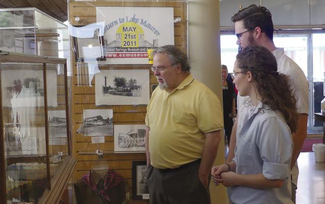 Jack Miles (from left), Sam Zimmerman and Rachel Grace admire Robert Grace’s artwork on display during the open house. ELIZABETH BARNT | Staff