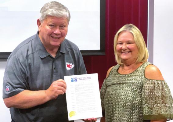 CLAY COUNTY Senior Services Board Member John McGovern receives the World Elder Abuse Awareness Day proclamation from Excelsior Springs Mayor Sharon Powell. BRIAN RICE | Staff photo