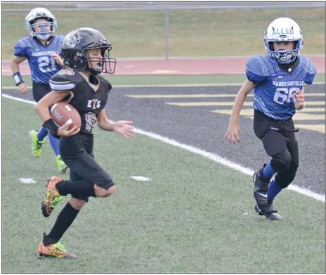 WITH TWO would-be Harrisonville tacklers in pursuit, Bryson Lingle heads toward the end zone for a touchdown for the Excelsior Springs third-grade youth football team Sept. 16 at Tiger Stadium. DUSTIN DANNER | Staff