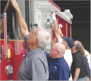 CITY OFFICIALS and first responders gather together drying off the new fire truck during wetting ceremony. See story on page 12. ELIZABETH BARNT | Staff