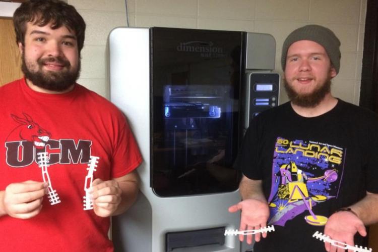 UNIVERSITY of Central Missouri students, Matthew Argotsinger, left, Peculiar, Missouri, and Cameron Rogers, Camdenton, Missouri, display ear guards that were made on a 3D printer and will help health care workers to be more comfortable wearing protective gear for long hours. UCM