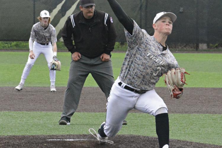 BACKED BY Cooper Collins at second base, Excelsior Springs junior Klayton Glaspy deals May 4 against visiting Willard as the field umpire watches his delivery.
