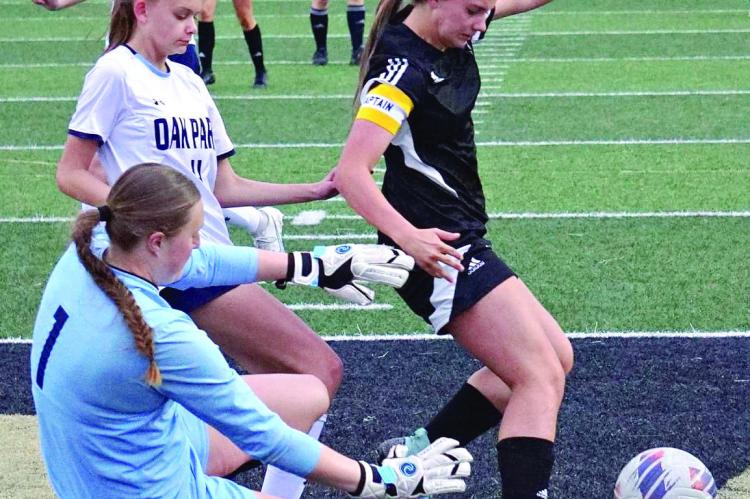 ABBY RASH (right) tries to get around Oak Park’s defense April 10 in the Excelsior Springs Tournament title game. The Excelsior Springs girls place second, winning their first two games and losing 3-0 to Oak Park. DUSTIN DANNER | Staff