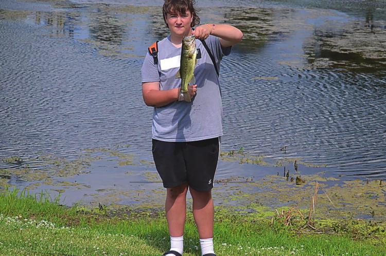 GRIFFIN SMITH shows off the bass he caught this week while fishing at Century Park in Excelsior Springs. Fishing is among the many outdoor activities area residents can enjoy this summer in Excelsior Springs. DUSTIN DANNER | Staff