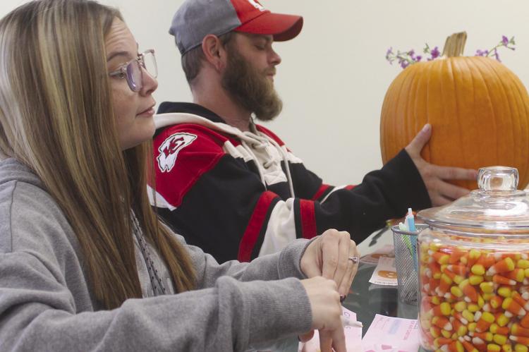 LAUREN (LEFT) and Michael Reavis guess the weight of a pumpkin and how many candy corns were in a jar, while celebrating the businesses one year anniversary. MIRANDA JAMISON | Staff
